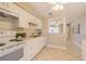 Functional kitchen with white appliances and cabinetry, complemented by tile flooring and ample counter space at 6702 49Th N Ave, St Petersburg, FL 33709