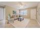 Cozy living room with neutral tones, ceiling fan, tile flooring, and access to the front door and a hallway at 6702 49Th N Ave, St Petersburg, FL 33709