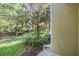 Lush backyard area with mature trees, a small lawn, and tropical landscaping at 6736 Breezy Palm Dr, Riverview, FL 33578
