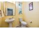 Bright bathroom featuring a pedestal sink, toilet, and a large mirror at 6736 Breezy Palm Dr, Riverview, FL 33578