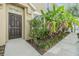 Charming home entrance featuring a dark brown door, lush landscaping and inviting walkway at 6736 Breezy Palm Dr, Riverview, FL 33578
