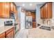 Modern kitchen featuring stainless steel appliances, granite countertops, and wood cabinetry at 6736 Breezy Palm Dr, Riverview, FL 33578