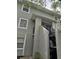 Exterior of a gray two-story townhouse with concrete stairs and black metal railings leading to the entrance at 7168 E Bank Dr # 7168, Tampa, FL 33617