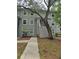 Exterior view of gray two-story townhouse, showcasing well-maintained landscaping and a walkway to the entrance at 7168 E Bank Dr # 7168, Tampa, FL 33617