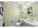 Compact bathroom featuring a pedestal sink, toilet, and washer/dryer at 7300 Sun Island S Dr # 605, South Pasadena, FL 33707