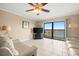 Bright living room featuring tile flooring, fan, and balcony access with serene views at 7300 Sun Island S Dr # 605, South Pasadena, FL 33707
