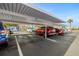 Covered parking area with multiple vehicles parked under a well-lit, numbered canopy at 7300 Sun Island S Dr # 605, South Pasadena, FL 33707