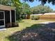 Expansive backyard with lush green grass, mature trees, and a shed at 7317 Mitchell Ranch Rd, New Port Richey, FL 34655