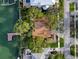 Aerial view of a home with a boat dock and lush, mature trees, located on the water at 761 Bay Esplanade, Clearwater Beach, FL 33767
