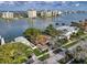 Aerial view of a home with mature landscaping and a boat dock with waterfront and city views at 761 Bay Esplanade, Clearwater Beach, FL 33767