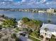 Aerial view of a home's backyard with mature trees along the waterway with lush green water at 761 Bay Esplanade, Clearwater Beach, FL 33767