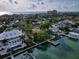Aerial view of beautiful homes on a waterfront property with a dock and clear blue skies at 761 Bay Esplanade, Clearwater Beach, FL 33767