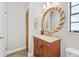 Bright bathroom with wood vanity and large circular mirror at 7633 Piping Rock Ct # 7633, New Port Richey, FL 34654