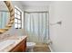The bathroom with tile surround features shower-tub combination and wood-look floor at 7633 Piping Rock Ct # 7633, New Port Richey, FL 34654