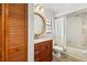 Bright bathroom features a wood vanity, unique mirror and shower-tub combo at 7633 Piping Rock Ct # 7633, New Port Richey, FL 34654