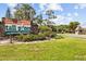 Entrance to Tall Pines at River Ridge shows lush landscaping and manicured lawns at 7633 Piping Rock Ct # 7633, New Port Richey, FL 34654