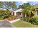 The single story home has a brown roof, a small front yard, and lots of trees at 7633 Piping Rock Ct # 7633, New Port Richey, FL 34654