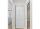 Hallway leading to bathroom, with folding door and wood-look flooring at 7633 Piping Rock Ct # 7633, New Port Richey, FL 34654