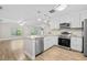 Bright kitchen featuring stainless steel appliances, an island, and wooden floors at 7633 Piping Rock Ct # 7633, New Port Richey, FL 34654