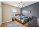 This bedroom has a ceiling fan, neutral walls, a blue accent wall and a neutral colored bed at 8124 Brinegar Cir, Tampa, FL 33647