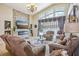 Bright living room featuring a stone fireplace, chandelier, and comfortable furniture at 8124 Brinegar Cir, Tampa, FL 33647