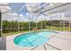 Screened-in pool area features a kidney-shaped pool and a view of the lake and landscaping at 8124 Brinegar Cir, Tampa, FL 33647