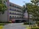 Multi-story condominium building with covered parking and nicely landscaped grounds and mature tropical trees at 8174 Terrace Garden N Dr # 204, St Petersburg, FL 33709