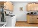 Bright laundry room with wood-look floors, storage cabinets, and modern appliances at 8174 Terrace Garden N Dr # 204, St Petersburg, FL 33709