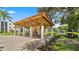 Open-air pavilion with picnic tables, grill, and view of the surrounding landscaping and pond at 8174 Terrace Garden N Dr # 204, St Petersburg, FL 33709