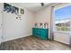 Bright bedroom featuring a blue dresser, wood-look flooring, and natural light from a large window at 8208 Praise Dr, Tampa, FL 33625