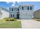 Charming two-story home featuring a well-maintained lawn and a two-car garage at 8208 Praise Dr, Tampa, FL 33625