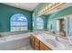 Bathroom with double vanity, soaking tub, a large arched window with beautiful outdoor views at 8253 118Th Ave, Largo, FL 33773