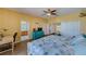 Bright bedroom with yellow walls, wood-look flooring, ceiling fan, ensuite bathroom, and a turquoise dresser at 8253 118Th Ave, Largo, FL 33773