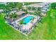 Aerial view of the community pool area with palm trees, lounge chairs, and well-manicured lawn at 8253 118Th Ave, Largo, FL 33773