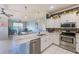 Bright eat-in kitchen with stainless appliances, double sink, breakfast bar, and white cabinetry open to the living area at 8253 118Th Ave, Largo, FL 33773