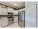 Updated kitchen features white cabinets, stainless steel appliances, decorative backsplash, and tile flooring at 8253 118Th Ave, Largo, FL 33773