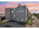 Modern multi-story building with ample parking and gray exterior under a beautiful sunset at 841 4Th N Ave # 55, St Petersburg, FL 33701