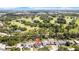 An aerial view showcases a lovely neighborhood and golf course with blue sky, interspersed with fair weather clouds, in the background at 8433 101St Ave, Seminole, FL 33777