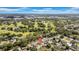 Expansive aerial view showcasing the property, neighboring houses, lush golf course, and blue sky with some clouds in the background at 8433 101St Ave, Seminole, FL 33777