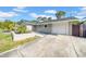 Charming single-story home featuring a well-maintained lawn, a garage, and a modern front door at 8433 101St Ave, Seminole, FL 33777