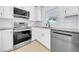 Modern kitchen featuring stainless steel appliances, white cabinets, and a bright window at 8433 101St Ave, Seminole, FL 33777