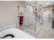 Luxurious bathroom with a glass walk-in shower, soaking tub, and marble floors at 903 Pinellas Bayway S # 103, Tierra Verde, FL 33715