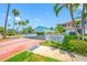 Community entrance sign with palm trees and lush landscaping on a sunny day at 903 Pinellas Bayway S # 103, Tierra Verde, FL 33715