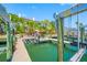 Exterior view of waterfront property featuring a boat lift and dock extending into the serene water at 903 Pinellas Bayway S # 103, Tierra Verde, FL 33715