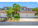 Exterior view of two-story home with red tile roof, tropical landscaping, and a two-car garage at 903 Pinellas Bayway S # 103, Tierra Verde, FL 33715