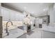 Bright kitchen features white cabinets, marble countertops, stainless steel appliances, and luxury tile floors at 903 Pinellas Bayway S # 103, Tierra Verde, FL 33715