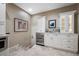 Kitchenette area with stainless steel wine fridge, custom white cabinetry, and marble countertops at 903 Pinellas Bayway S # 103, Tierra Verde, FL 33715