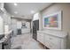 Kitchen features white cabinetry, stainless steel refrigerator, marble countertops, and adjacent wine storage at 903 Pinellas Bayway S # 103, Tierra Verde, FL 33715