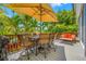 Deck area with an umbrella, seating area and stunning tropical plants with a waterfront view at 903 Pinellas Bayway S # 103, Tierra Verde, FL 33715