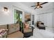 Light-filled sun room with stylish furnishings and sliding doors to a peaceful outdoor area at 903 Pinellas Bayway S # 103, Tierra Verde, FL 33715
